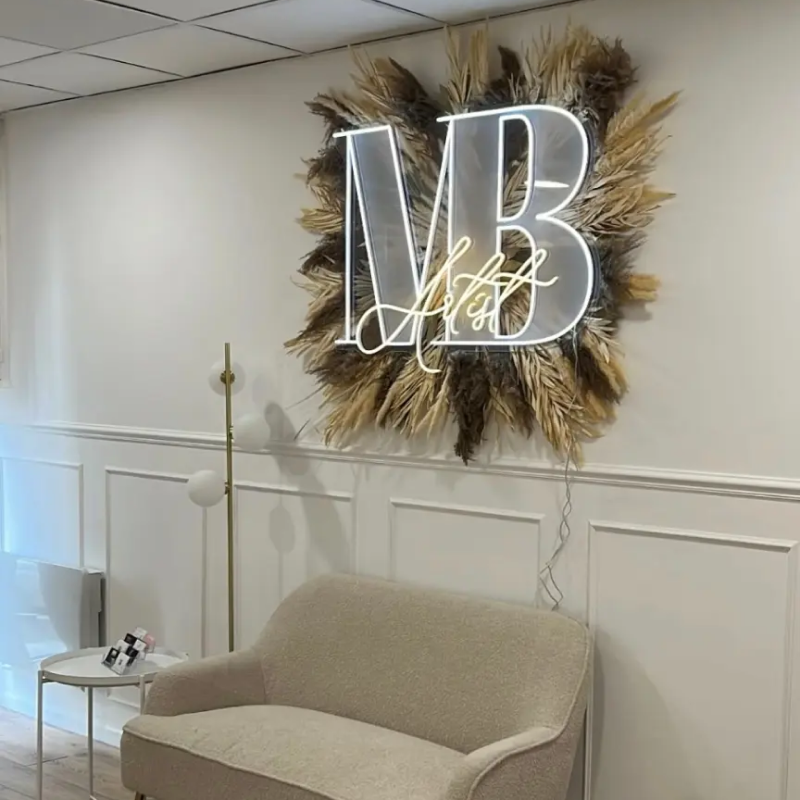 Enseigne néon personnalisée blanche « MB » installée dans un salon moderne