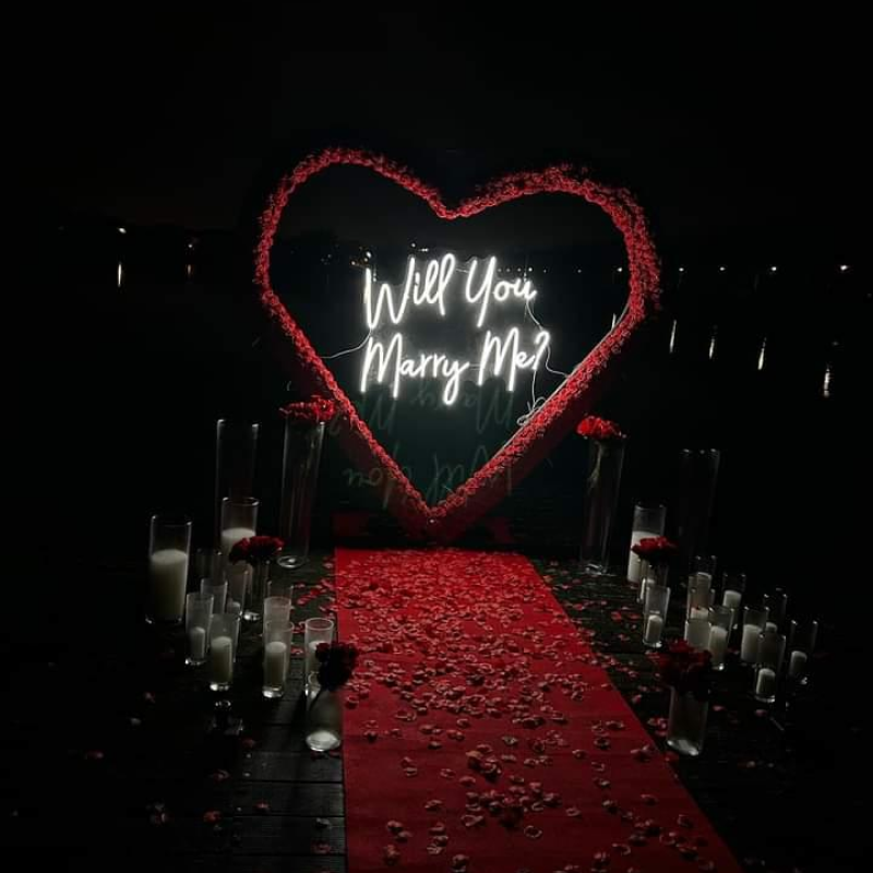 Enseigne néon romantique « Will You Marry Me » dans un cœur de roses rouges pour demande en mariage